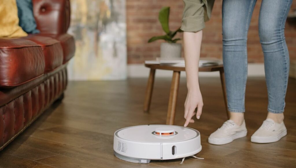 A lady putting on a robot vacuum