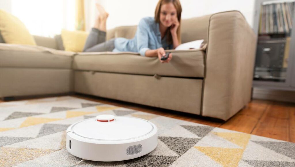 A woman lying on her sit watching the robot vaccum